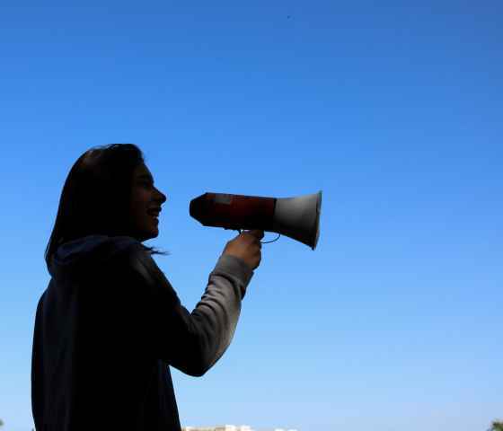 Person in shadows holding megaphone